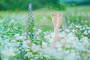 Relaxing in the nature Woman legs between flowers spa