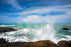 Relaxing ocean waves crashing into rocky shore on sunny summer