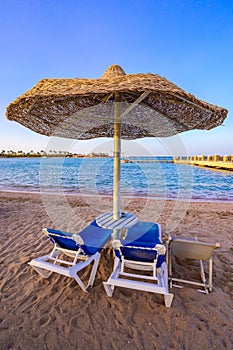 Relaxing at paradise beach - Chaise lounge and parasols - travel destination Hurghada, Egypt