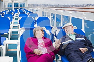 Relaxing Senior Couple Hold Hands On The Deck Of Cruise Ship