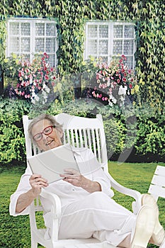 Relaxing Senior Woman in her garden on her tablet device