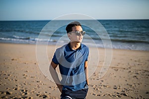 Relaxing and smiling asian young man on the beach