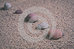 relaxing stones laying on sand textured pattern - vintage retro look
