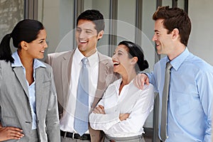 Relaxing after a stressful business pitch. A business team laughing together after a successful business pitch.