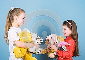 Relaxing together. playground in kindergarten. little sisters girls playing game in playroom. small girls with soft bear