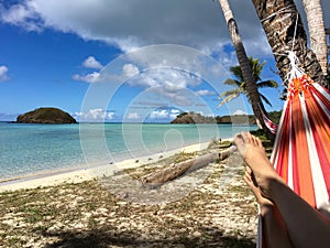 Relaxing under coconut trees shade on colourful hammock