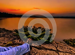 Relaxing Under an Orange Sunset Over a Calm Lake