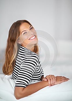 Relaxing and unwinding is more fun than youd think. Portrait of an attractive young woman sitting on the sofa at home.