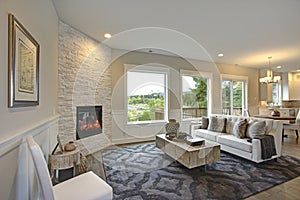 Luxury living room features corner stone fireplace