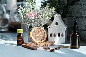 Relaxing winter season Essential oils blend. Dark glass bottles, cinnamon, orange, pine twigs, anise.