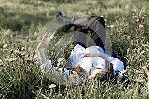 Relaxing woman lying on spring blooming meadow. Girl resting in spring park.