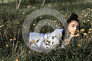 Relaxing woman lying on spring blooming meadow. Girl resting in spring park. Enjoy life