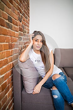 Relaxing woman sitting comfortable in sofa lounge chair smiling happy looking at camera Resting