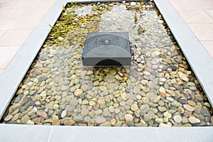 Relaxing zen fountain with pebbles and grass