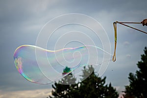 Releasing huge colorful soap bubbles in the open air