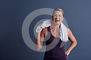 Releasing some endorphins. Studio portrait of an attractive mature woman in sportswear standing with a towel around her