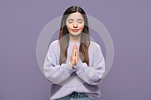 Releasing stress. Calm and focused on her thoughts multiracial woman against purple background