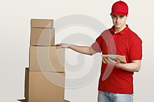 Reliable delivery. Courier checks parcels in warehouse with tablet