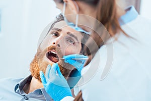 Reliable dentist using sterile instruments while cleaning the te