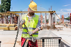 Reliable worker checking the safety latch of a hook before lifti