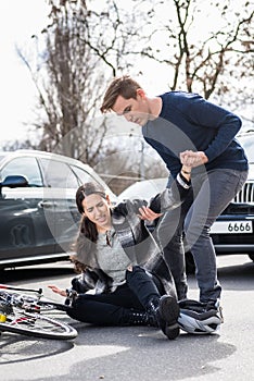 Reliable young man helping an injured woman while waiting for the ambulance