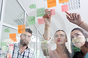 Reliable young workers posting reminders in a modern co-working space photo