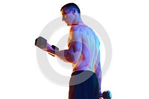Relief back. Muscular, shirtless, athletic young man lifting dumbbells, training against white studio background in neon