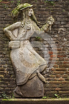 The relief a dancing woman on the brick wall.