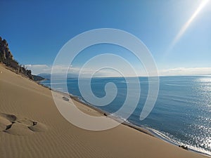Sea view on the horizon over a sand dune photo