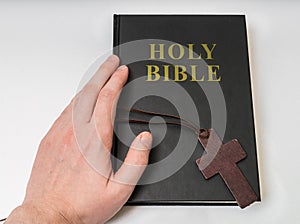 Religion concept. Hand touches Holy Bible