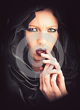 Religion and death concept. religion woman with makeup in black mysterious hood.