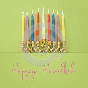 Religion image of jewish holiday Hanukkah background with menorah traditional candelabra and candles over pastel green