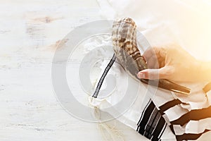 Religion image of shofar horn on white prayer talit. Rosh hashanah jewish New Year holiday, Shabbat and Yom kippur concept