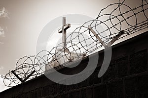 Religion and war - cross behind barbed wire