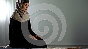 Religious arab woman sitting on islamic praying rug, religious worship, faith