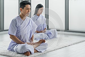 Couple having sitting meditation together for calm and peaceful mind photo