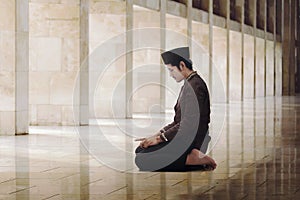 Religious asian muslim man with black cap praying