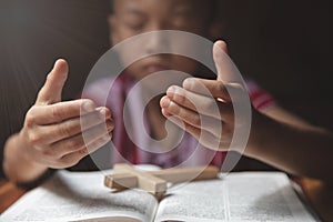 Religious Christian Child  praying over Bible indoors, Religious concepts. Religious beliefs Christian life crisis prayer to god