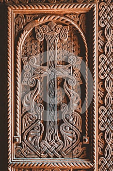 religious cross carved in a wooden door at the entrance to an ancient Armenian church