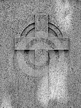 Religious Cross embossed on a weathered ancient granite tombstone