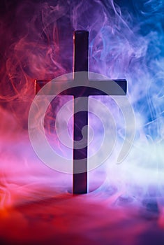 Religious cross surrounded by red and blue smoke symbolizing Heaven and Hell, good and evil, right and wrong, or other metaphor