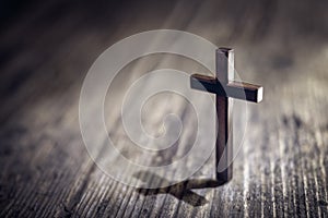 Religious crucifix cross upright on wooden table background