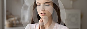 Religious dreamy young woman praying with hope wide image