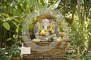 Religious elephant stone sculpture of Ganesha god in garden.