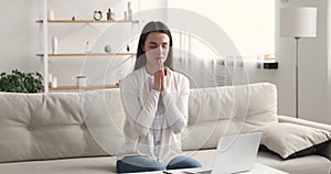 Religious focused young beautiful girl praying God at home.