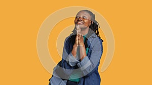 Religious girl doing worship gesturing, waiting for miracle, studio background