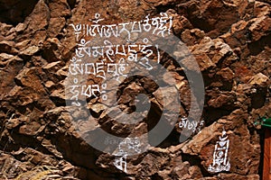 Religious inscription with Mongolia symbol on orange rocks in Tovkhon Monastery, Ovorkhangai Province, Mongolia.