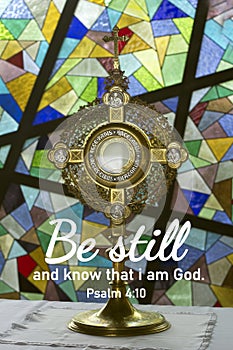 Religious inspirational quote from bible verse psalm 4:10 - Be still and know that I am God. With Eucharistic adoration chapel.