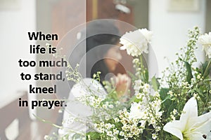 Religious inspirational quote - When life is too much to stand, kneel in prayer. With blurry face of young woman praying.