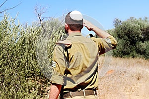 Religious Israeli Soldier with staff sergeants Israel Defense Forces saluted in nature photo